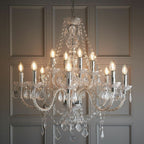 Maison Ornate Modern Crystal Chandelier features 12 candle bulbs, crystal arms, beads, and sparkling prisms.